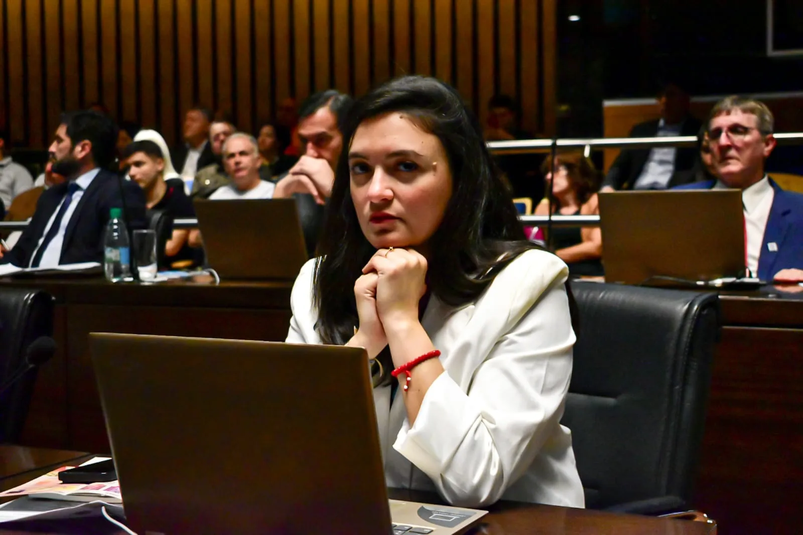 La diputada provincial Anazul Centeno sentada en su banca, con una computadora portátil